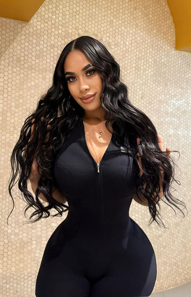 Brunette massage therapist in a tight-fitting black jumpsuit