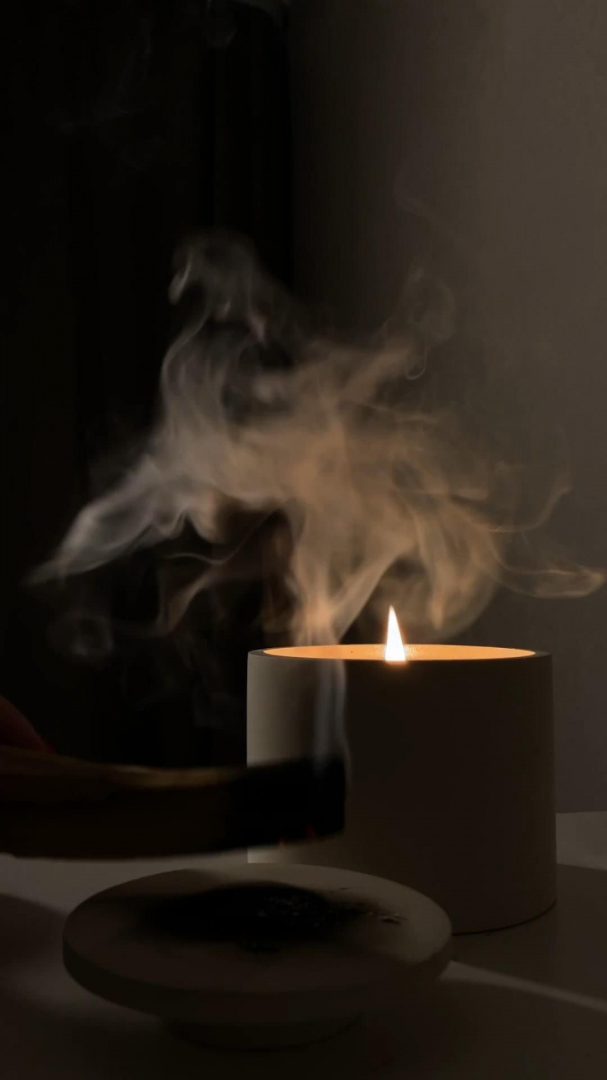 Smoky incense against the backdrop of a candle