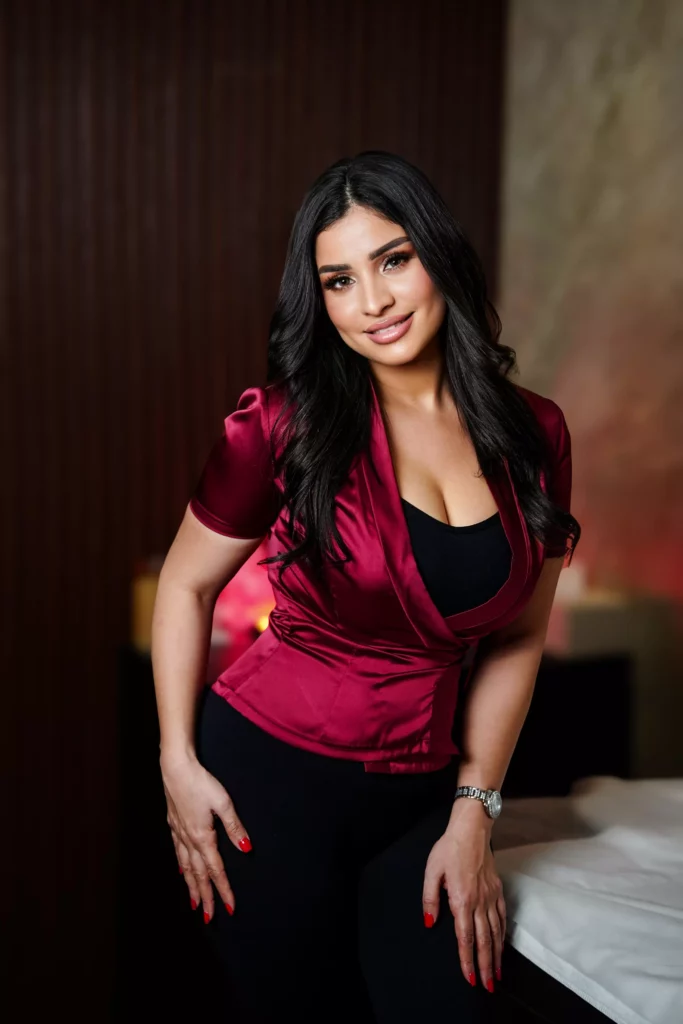 Dark-haired masseuse in a red satin shirt