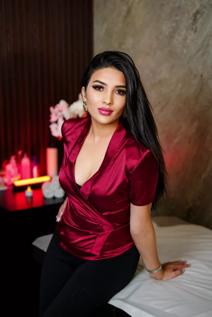 Dark-haired masseuse wearing a red satin shirt